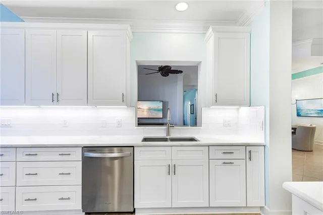 a kitchen with granite countertop white cabinets and white appliances