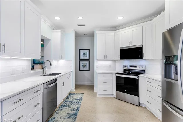 a kitchen with stainless steel appliances granite countertop a sink and dishwasher a stove top oven with wooden floor
