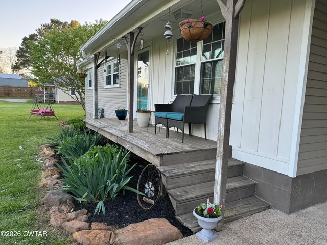 a front view of a house with porch and garden
