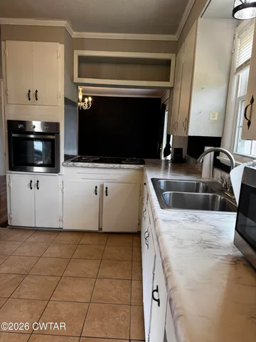 a kitchen with granite countertop a sink and a stove top oven