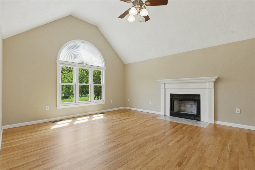 25 Sandra Road Peabody, MA 01960 - Photo 17 of 41 an empty room with wooden floor fireplace and windows
