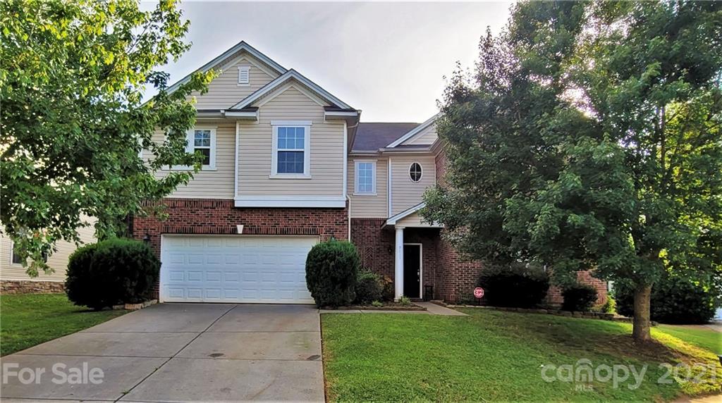 a front view of a house with a yard and garage