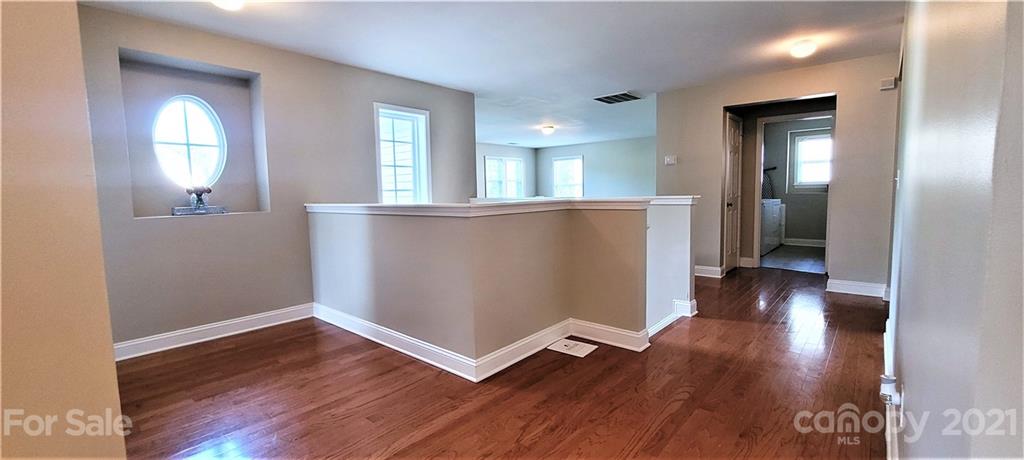 9611 Seamill Road Charlotte, NC 28278 - Photo 13 of 26 an empty room with wooden floor and windows