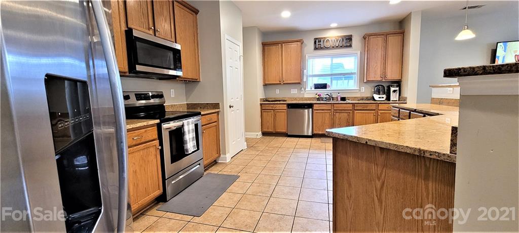 9611 Seamill Road Charlotte, NC 28278 - Photo 4 of 26 a kitchen with stainless steel appliances granite countertop a refrigerator a stove a sink and a microwave