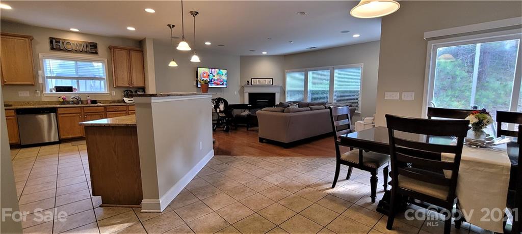 9611 Seamill Road Charlotte, NC 28278 - Photo 6 of 26 a kitchen with stainless steel appliances granite countertop a refrigerator a stove top oven and a dining table with wooden floor