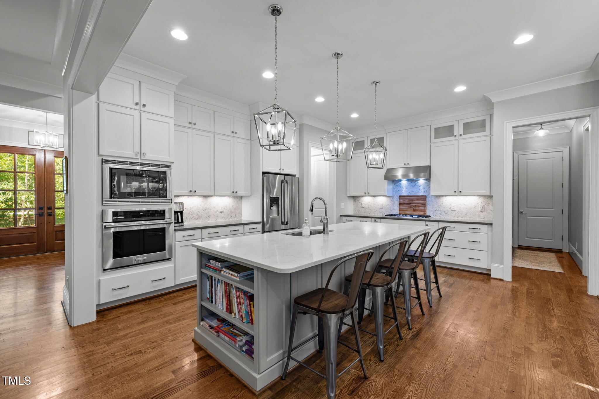 3005 Club Drive Raleigh, NC 27613 - Photo 12 of 45 a kitchen with stainless steel appliances a kitchen island hardwood floor sink stove dining table and chairs