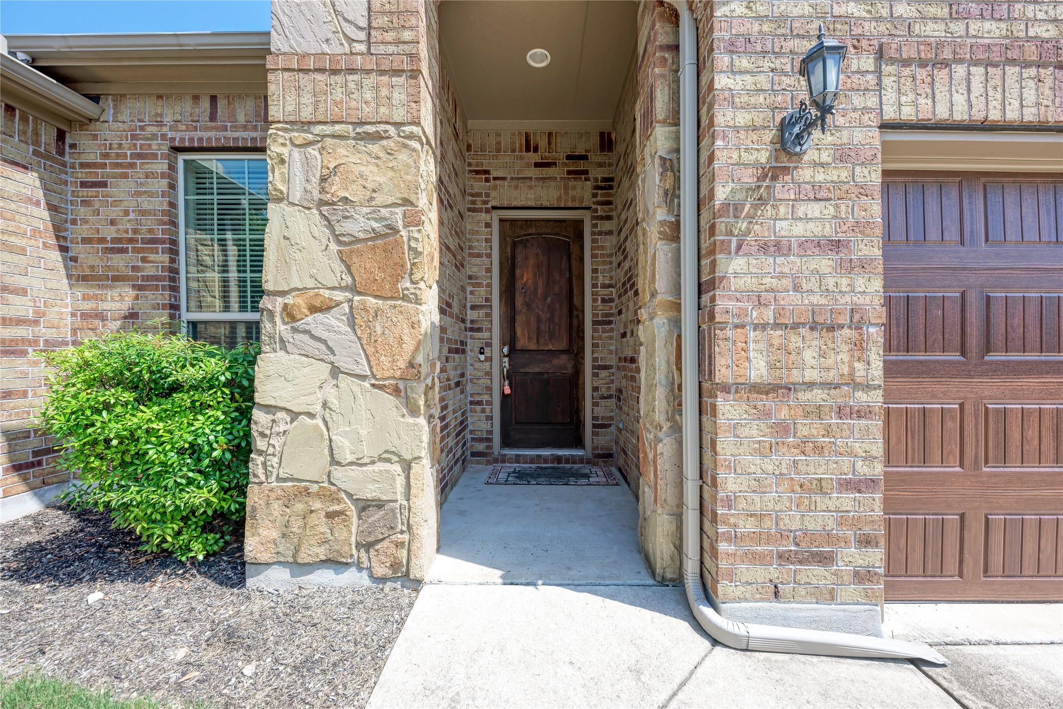 600 Rosedale Boulevard Georgetown, TX 78628 - Photo 4 of 28 A welcoming front entrance features a classic wooden door framed by rich brick and natural stone accents.