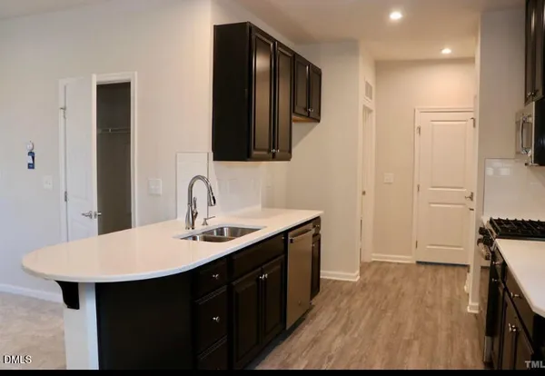 a kitchen with a sink and wooden floor