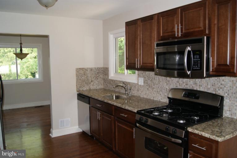 2302 Kingsway Road Fort Washington, MD 20744 - Photo 25 of 30 a kitchen with granite countertop a stove and a sink