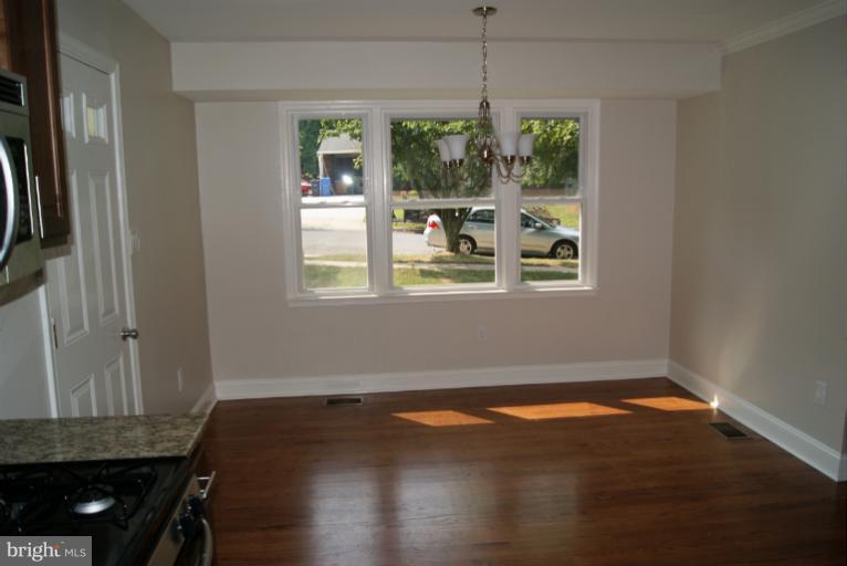2302 Kingsway Road Fort Washington, MD 20744 - Photo 26 of 30 an empty room with wooden floor a chandelier fan and windows