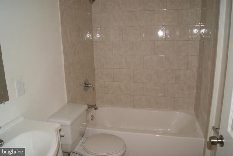 2302 Kingsway Road Fort Washington, MD 20744 - Photo 28 of 30 a bathroom with a granite countertop toilet a sink and bathtub