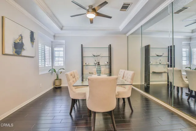 a dining room with furniture a chandelier and wooden floor