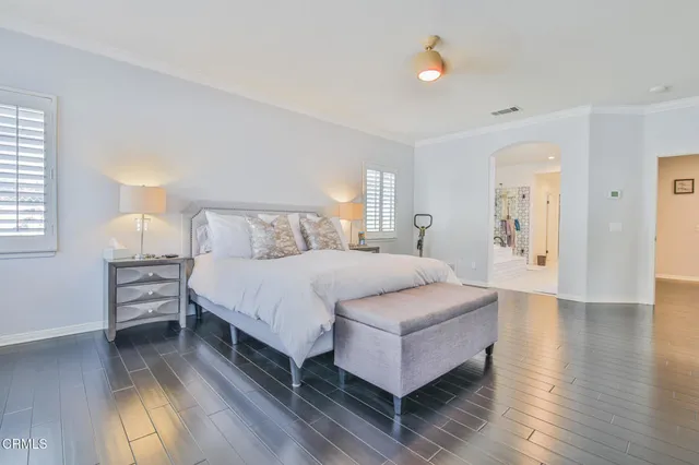 a spacious bedroom with a bed and wooden floor