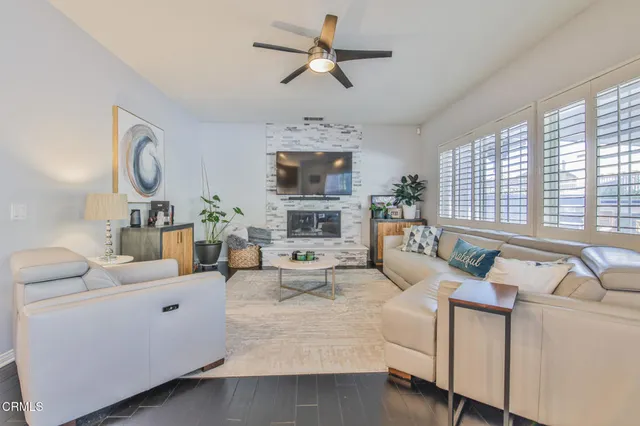 a living room with furniture fireplace and a large window