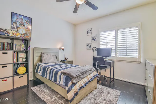 a bedroom with a bed and painting on the wall