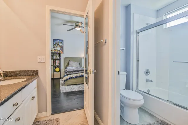 a bathroom with a granite countertop sink toilet and shower