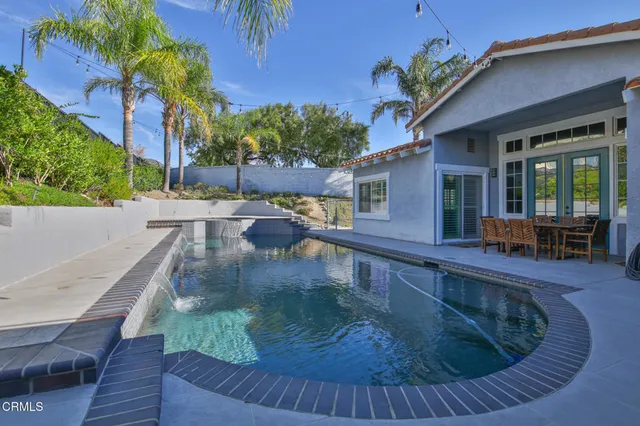 a view of a house with pool and sitting area