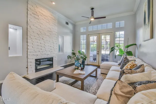 a living room with furniture fireplace and a large window