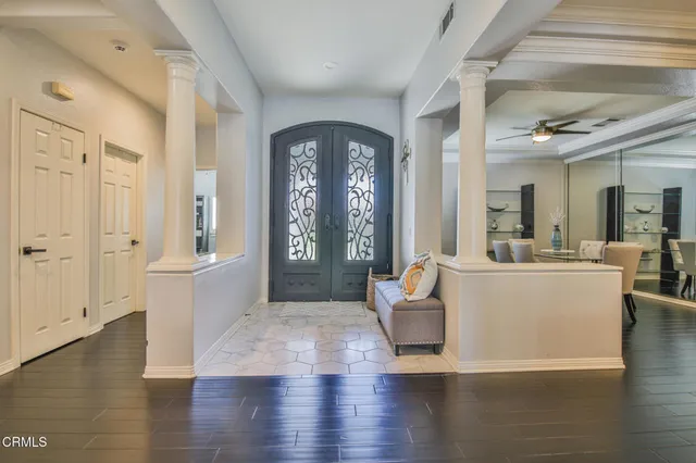 a living room with couches and a large mirror with wooden floor