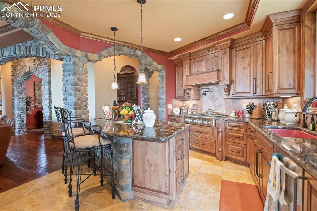 2017 County Road 1 Road Cripple Creek, CO 80813 - Photo 14 of 42 a kitchen with stainless steel appliances granite countertop a stove top oven a sink a dining table and chairs with wooden floor