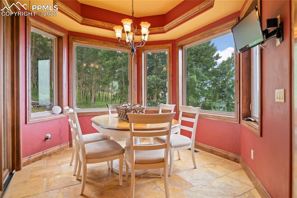 2017 County Road 1 Road Cripple Creek, CO 80813 - Photo 21 of 42 a dining room with furniture a chandelier and large windows