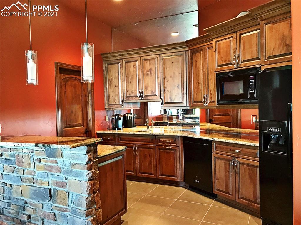 2017 County Road 1 Road Cripple Creek, CO 80813 - Photo 28 of 42 a kitchen with stainless steel appliances granite countertop a sink stove and refrigerator