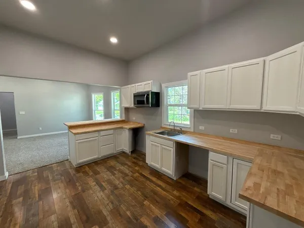a view of an empty room with window and cabinet