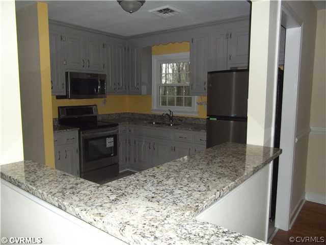 7731 Varann Road Henrico, VA 23231 - Photo 7 of 24 a kitchen with a stove and a refrigerator