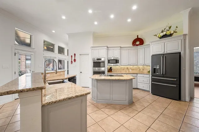 a kitchen with stainless steel appliances granite countertop a refrigerator and a sink