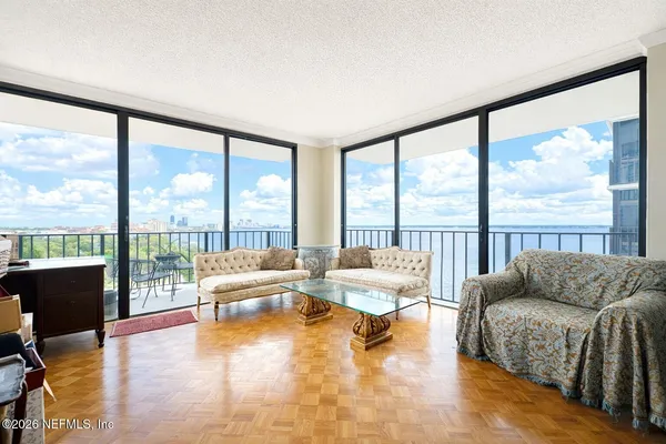 a living room with furniture and floor to ceiling windows