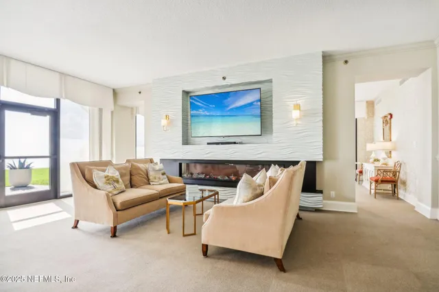 a living room with furniture a table and large windows