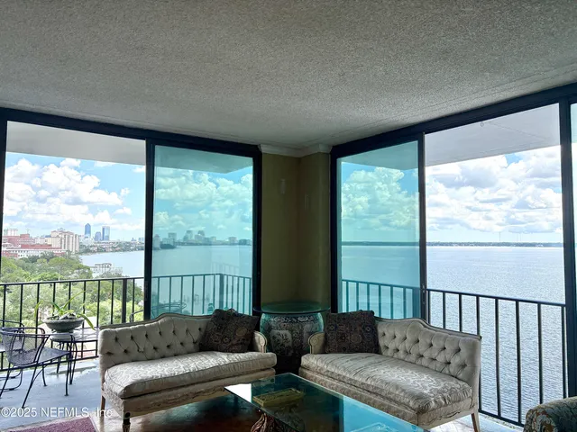 a living room with furniture and a floor to ceiling window