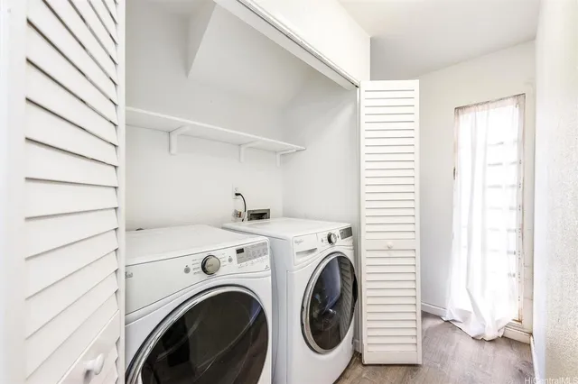 a view of washer and dryer with bathroom in the background