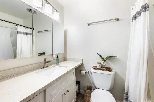 a bathroom with a toilet a sink and a mirror