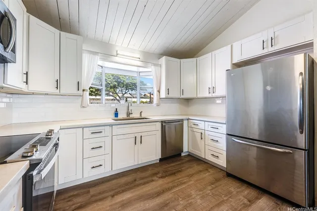 a kitchen with stainless steel appliances granite countertop a refrigerator sink and stove