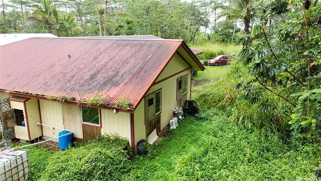 a aerial view of a house with table and chairs under an umbrella