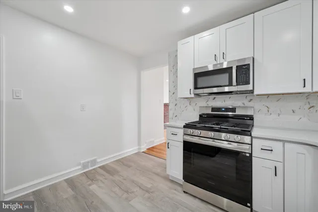 a kitchen with stainless steel appliances a stove a microwave and cabinets