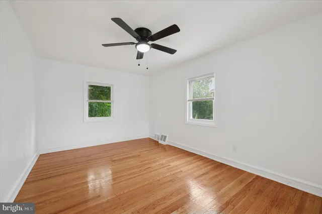 a view of a big room with wooden floor and windows
