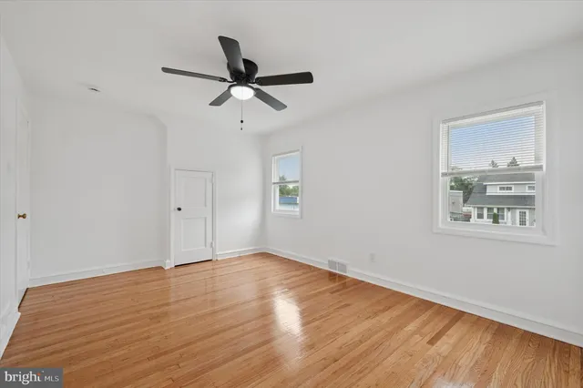 a view of empty room with wooden floor