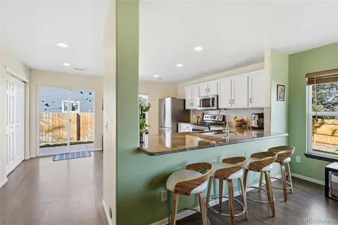 a kitchen with stainless steel appliances kitchen island granite countertop a refrigerator and microwave