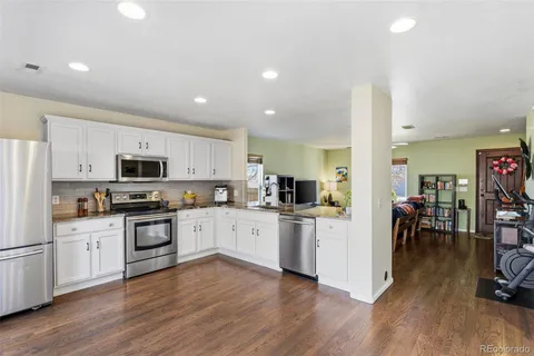 a kitchen with white cabinets and stainless steel appliances
