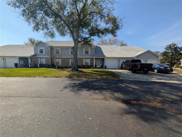 a view of a house with a yard and large tree