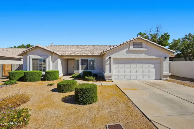 a front view of a house with a yard and potted plants