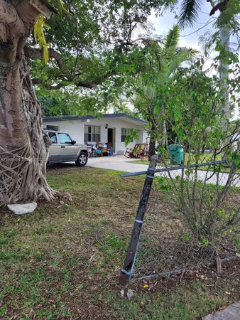 a view of a house with backyard and a tree