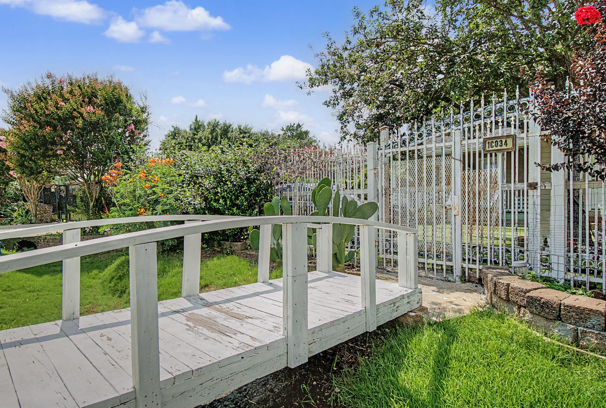 10034 Alfred Lane Houston, TX 77041 - Photo 2 of 50 Your own storybook setting awaits with lush landscaping, colorful blooms, and a charming garden bridge that adds character and tranquility.