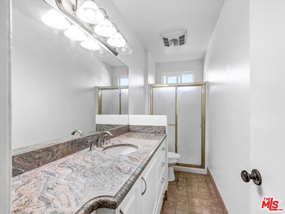 12479 Walsh Avenue Los Angeles, CA 90066 - Photo 8 of 21 a bathroom with a granite countertop sink a mirror and shower