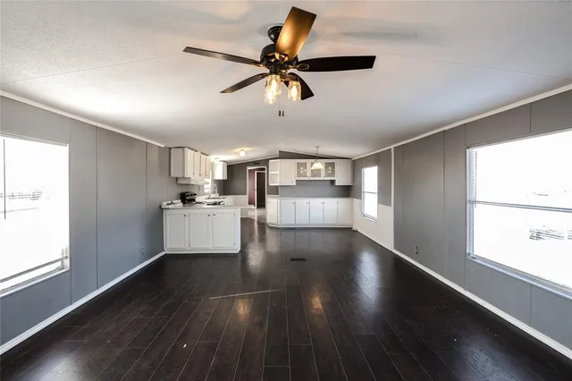 a view of empty room with wooden floor and window