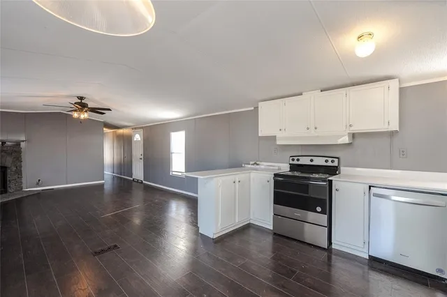 a kitchen with granite countertop a stove and a wooden floors