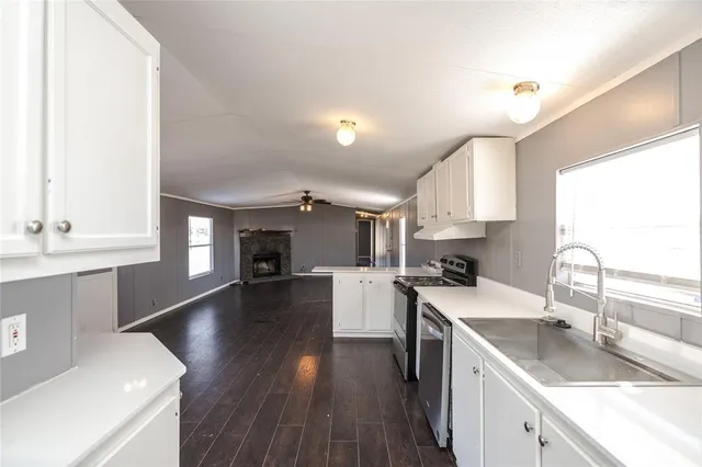 a kitchen with a sink cabinets and wooden floor