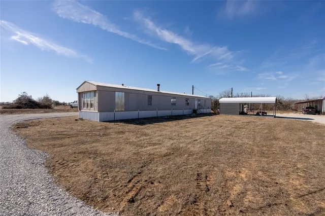 a view of a dry yard with wooden fence